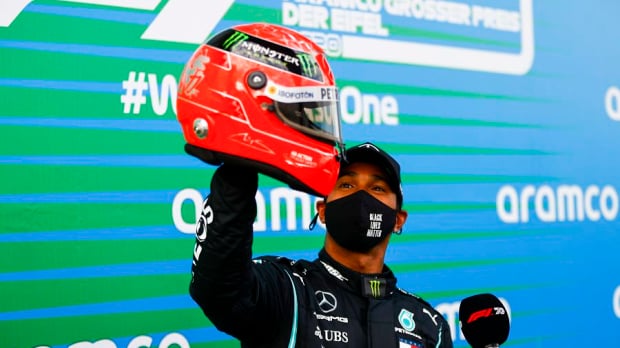 Lewis Hamilton with a helmet of Michael Schumacher