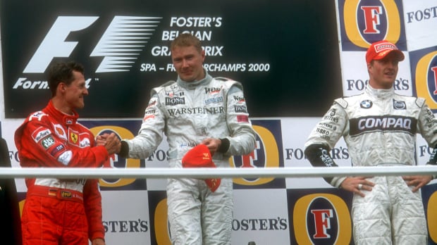 Michael Schumacher congratulates Mika Hakkinen on the Belgian Grand Prix podium in 2000 as Ralf Schumacher looks on — Photo: © IMAGO