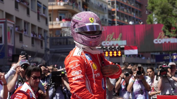 Hamilton with pink F1 helmet on in Ferrari race suit on Monaco GP grid — Photo: © IMAGO