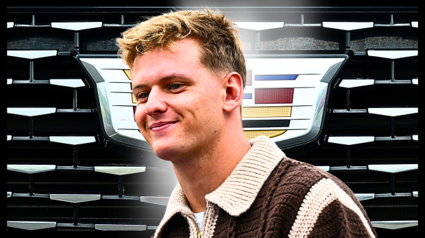 Mick Schumacher in front of a Cadillac logo looking happy