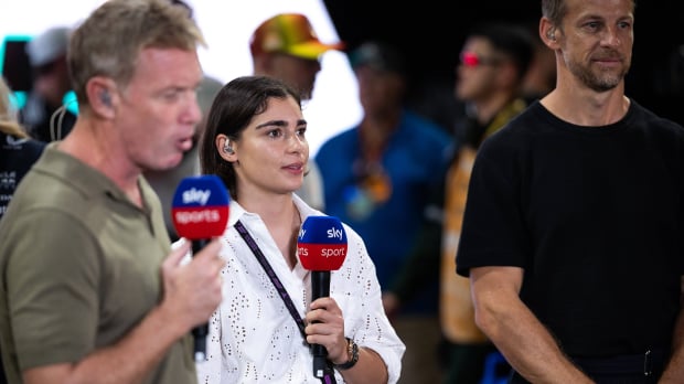 Jamie Chadwick on air with Sky Sports holding a mic stood between Simon Lazenby and Jenson Button who are out of focus