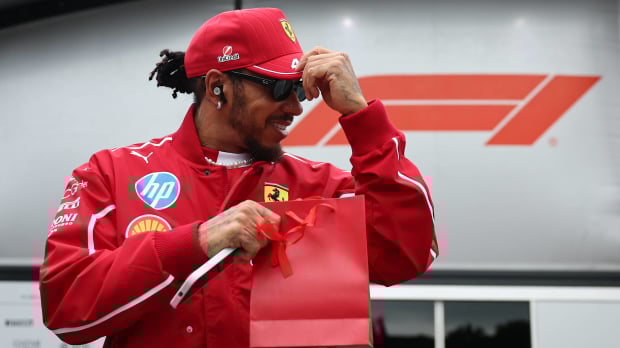 Lewis Hamilton holds onto his hat in the paddock at Baku