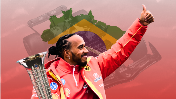 Lewis Hamilton waves and smiles as he holds a trophy with the brazil flag in the background