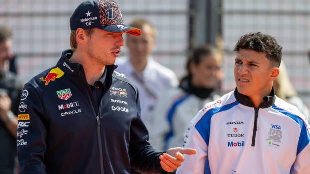 Verstappen and Hadjar mid-discussion on a paddock walk
