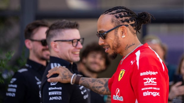 Hamilton walking past Bono touching his shoulder with a smile at the Chinese GP — Photo: © IMAGO