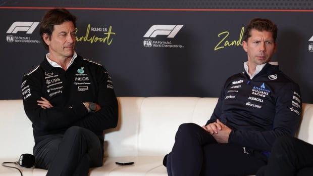 Wolff looking at Vowles with pride as Vowles looks away, both sat next to each other on the FIA press conference sofa