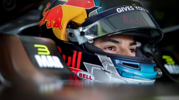 Pepe Marti sits in his Formula E car with his Red Bull-inspired helmet on
