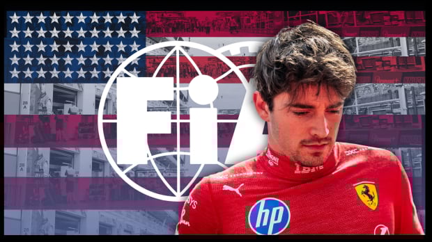 Leclerc in Ferrari race suit looking down with a glum expression in front of a US flag-themed FIA logo
