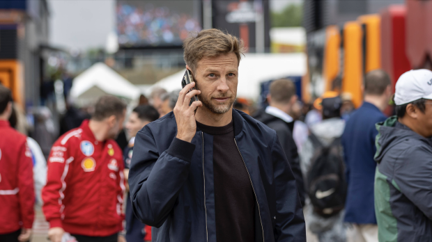 Jenson Button takes a phone call while walking in the paddock at Silverstone