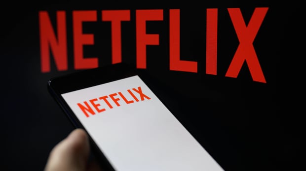Netflix logo on TV, with smartphone displaying the same logo next to it