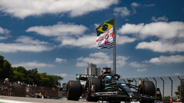 George Russell drives at the Brazilian Grand Prix with a Brazil flag flying in the background