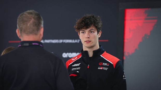 Oliver Bearman chats to a fellow team member at Haas — Photo: © IMAGO