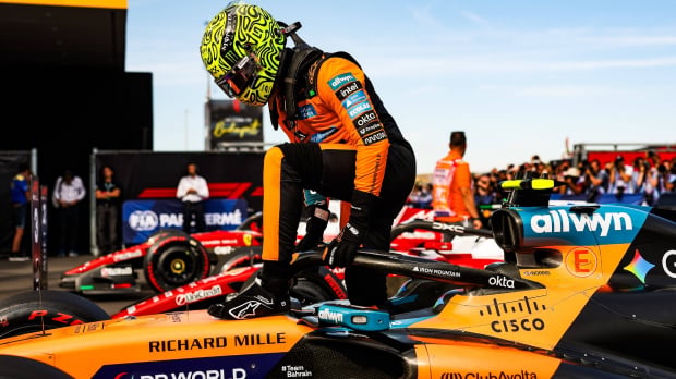 Norris kneeling on top of his McLaren F1 car after claiming Hungarian GP pole — Photo: © IMAGO