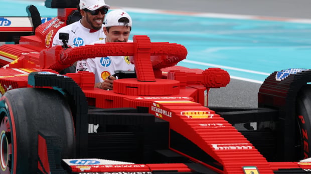 Lewis Hamilton and Charles Leclerc laugh as they drive a Ferrari Lego F1 car — Photo: © IMAGO