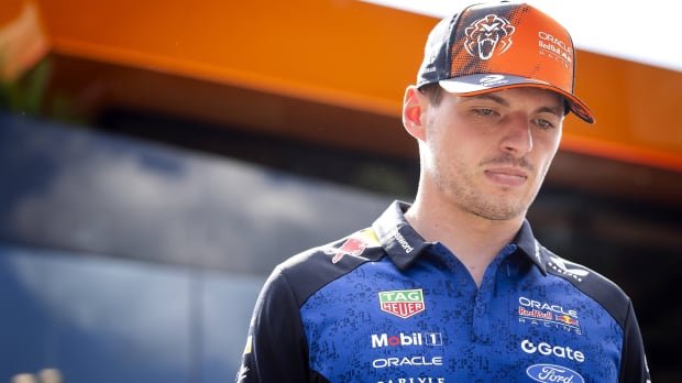 Verstappen in orange cap and navy Red Bull top looking serious at Austrian GP — Photo: © IMAGO