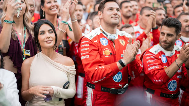 Kim K smiling in the crowd beneath Monaco podium next to Ferrari team members — Photo: © IMAGO