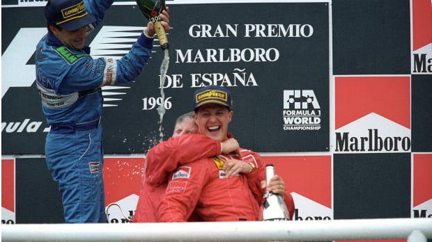 Jean Alesi pours champagne on Ferrari boss Jean Todt and Michael Schumacher