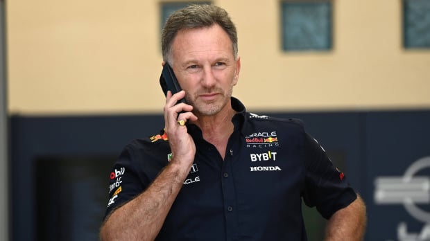 Horner in Red Bull kit looking down at his phone