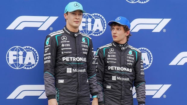 Russell and Antonelli in Mercedes race suits against the FIA and F1 blue and white screen backdrop — Photo: © IMAGO