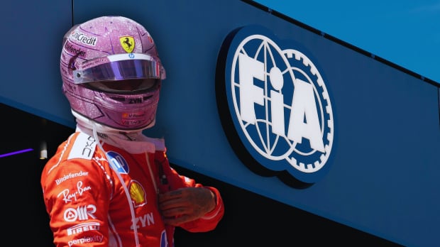 Hamilton in pink F1 helmet in Ferrari race suit with white FIA logo on a blue building in the background — Photo: © IMAGO