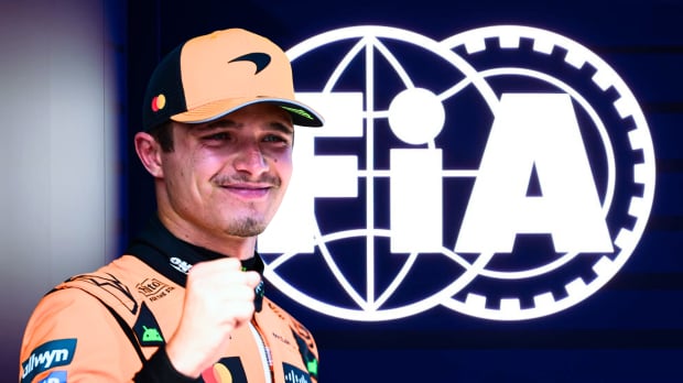 Norris making a triumphant fist edited in front of a blue FIA sign with the white logo