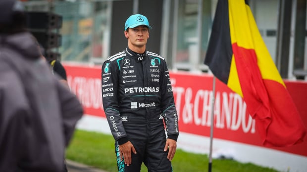 George Russell looks forlorn at the Belgian Grand Prix in front of the Belgian flag — Photo: © IMAGO