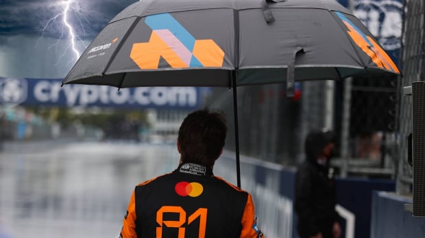 Oscar Piastri holds an umbrella as a superimposed lightning bolt hits his umbrella at the Miami GP — Photo: © IMAGO