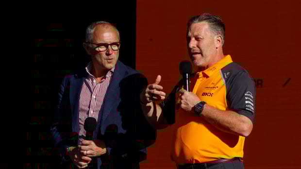 Domenicali in a suit stood next to Brown in McLaren F1 kit, both holding mics on stage at McLaren event in Trafalgar Square — Photo: © IMAGO