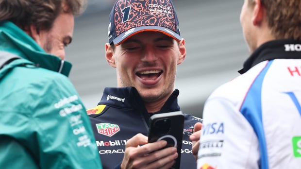Max Verstappen laughing as he looks at his phone — Photo: © IMAGO