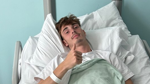 Will Macintyre gives a thumbs up from a hospital bed
