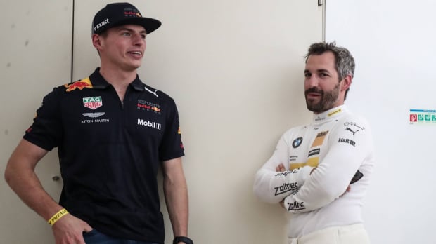 Verstappen and Glock stood leaning against a white wall talking to each other — Photo: © IMAGO