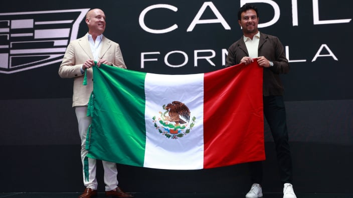 Cadillac F1 CEO Dan Towriss holding Mexican flag with Sergio Perez