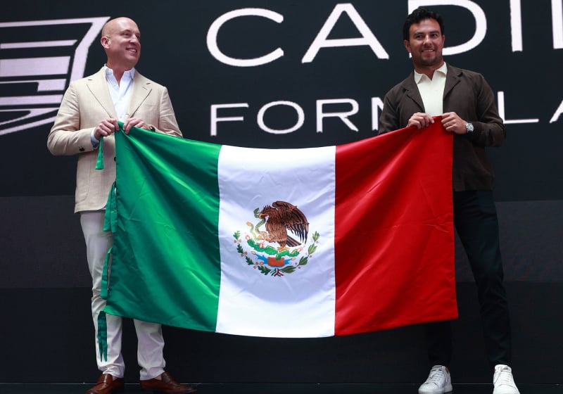 Cadillac F1 CEO Dan Towriss holding Mexican flag with Sergio Perez