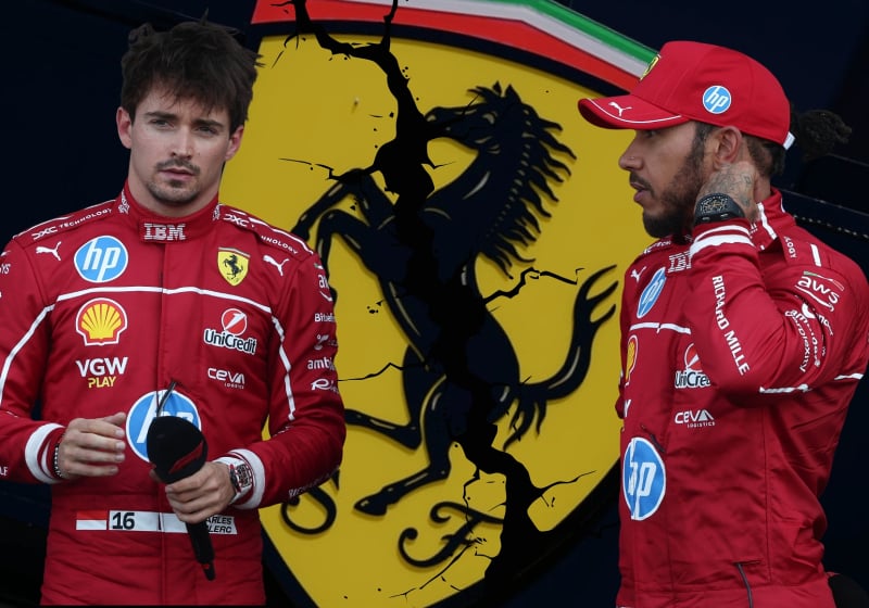 Charles Leclerc and Lewis Hamilton stand in front of an edited cracked Ferrari badge