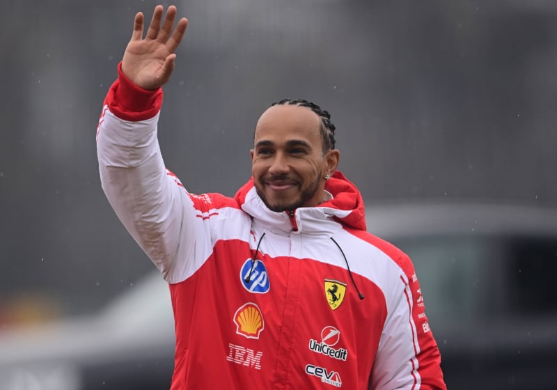 Hamilton in new Ferrari red and white F1 jacket waving at Fiorano