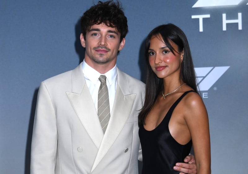 Charles Leclerc and partner Alexandra Saint Mleux posing on F1 Movie premiere carpet in a suit and a dress