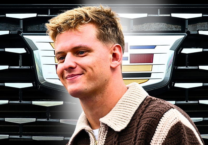 Mick Schumacher in front of a Cadillac logo looking happy