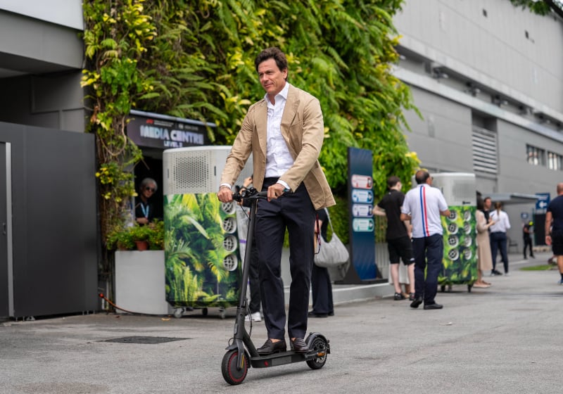 Toto Wolff rides a scooter in the paddock at the 2025 Singapore Grand Prix