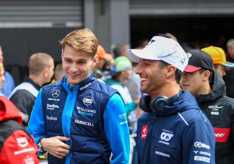 Logan Sargeant and Daniel Ricciardo share a joke at the Belgian Grand Prix