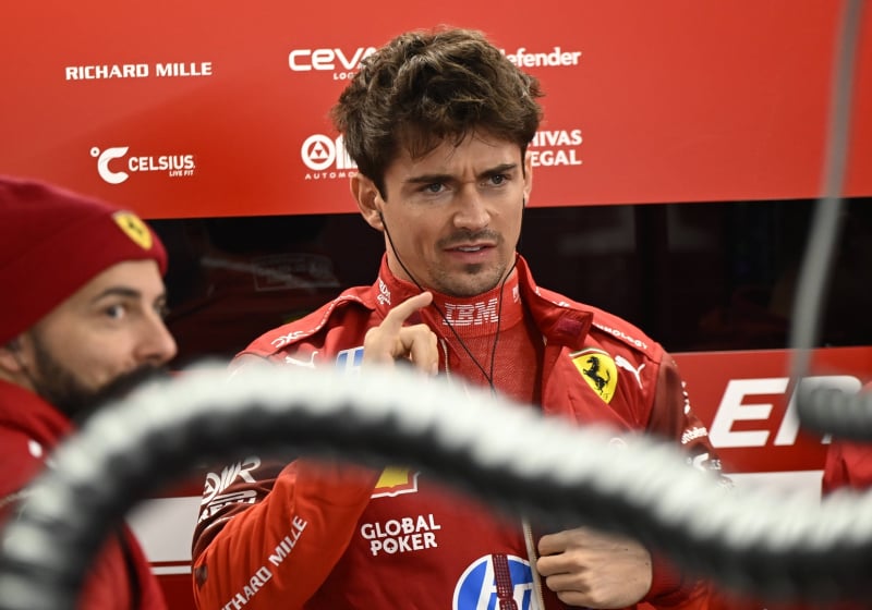 charles leclerc in the Ferrari garage looking annoyed