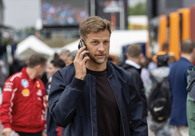 Jenson Button takes a phone call while walking in the paddock at Silverstone