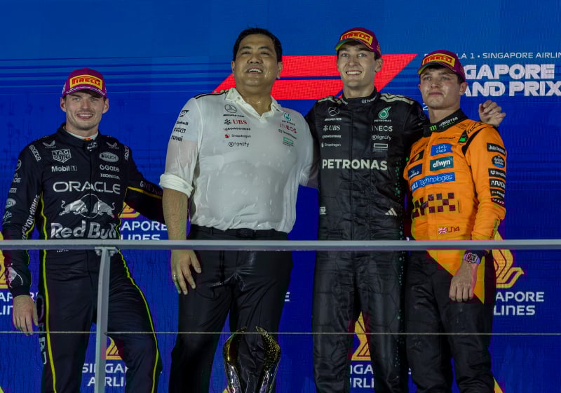 George Russell, Max Verstappen and Lando Norris stand on the Singapore Grand Prix podium 2025