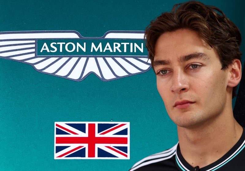 George Russell in front of an Aston Martin logo