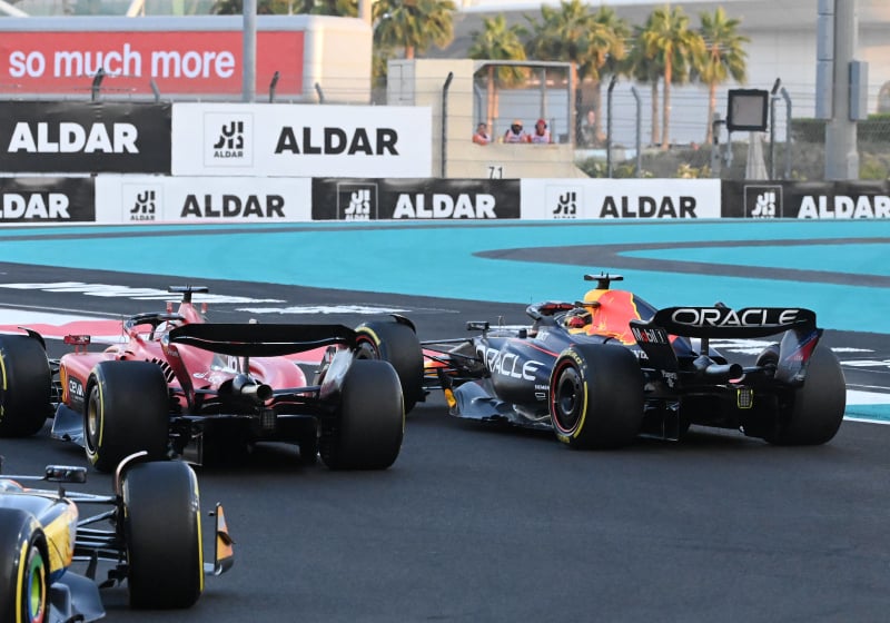 A Ferrari dives down the inside of a Red Bull at the Abu Dhabi Grand Prix