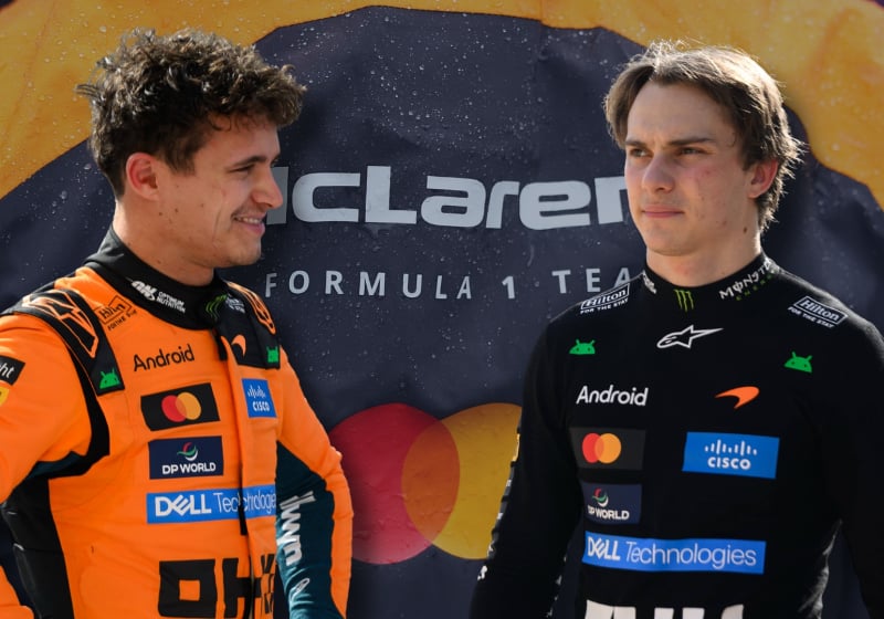 Lando Norris and Oscar Piastri look at each other with a McLaren logo background