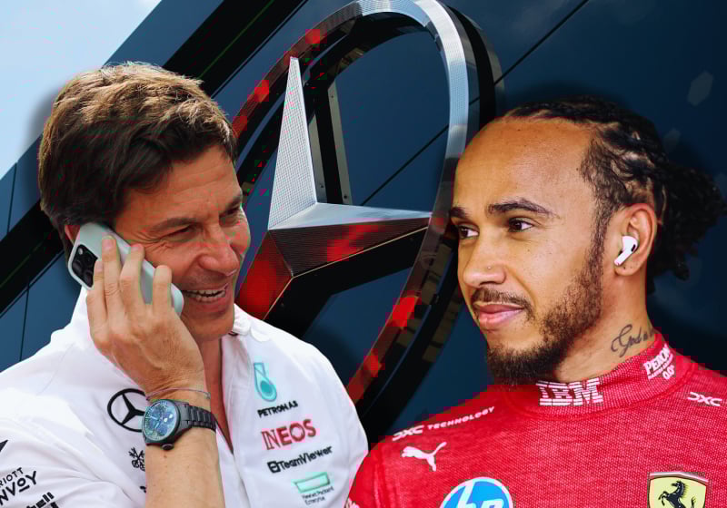 Toto Wolff laughing with Lewis Hamilton in front of Mercedes logo