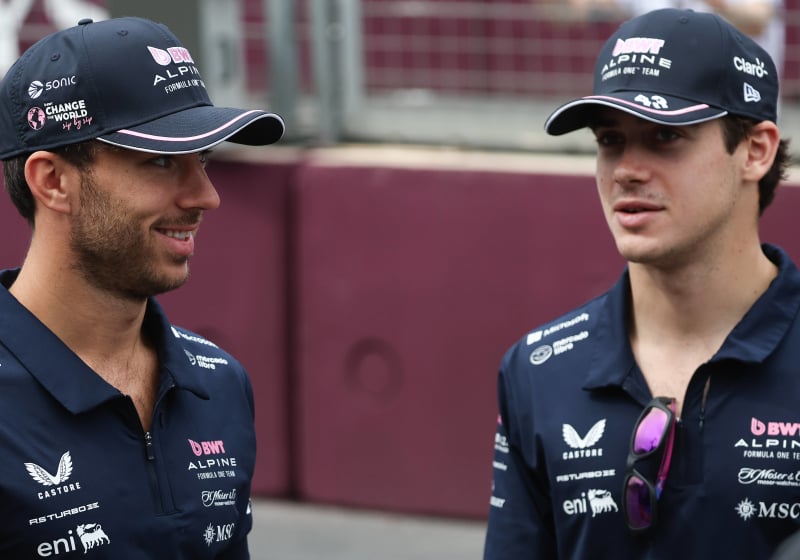 Pierre Gasly smiles at Franco Colapinto as they both stand in their Alpine team gear
